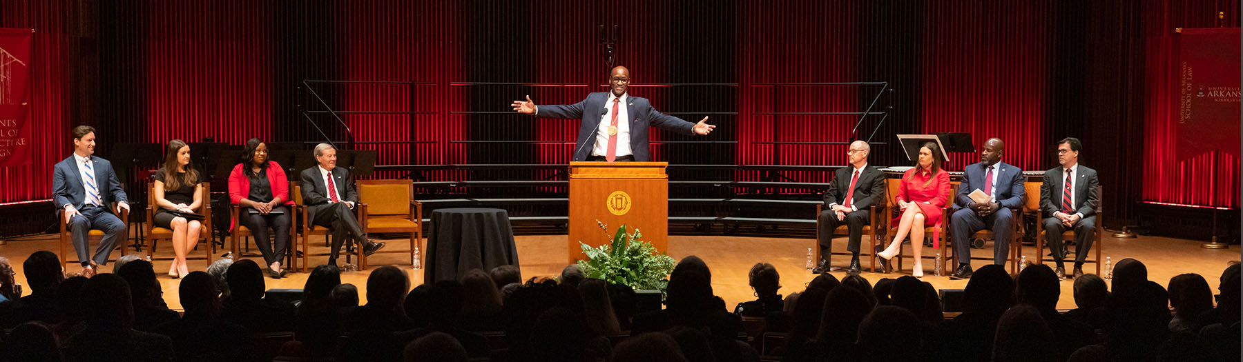Charles Robinson makes closing remarks at his investiture ceremony with a wide arm gesture.